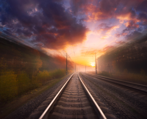 Railway in motion at sunset with dramatic sky with blur effect.
