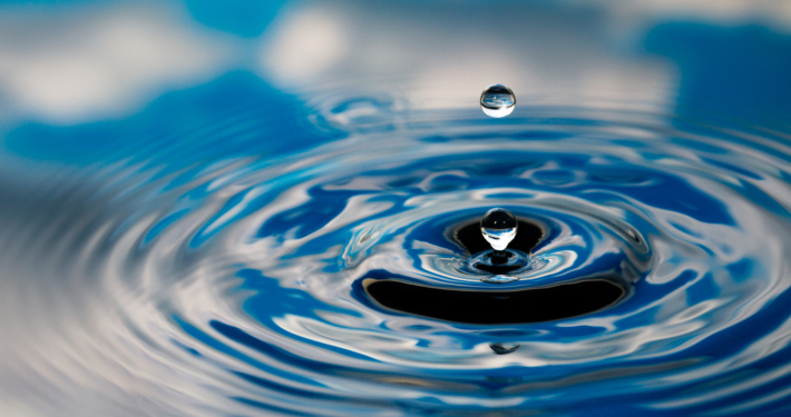 Water drops splashing with a blue cloudy sky