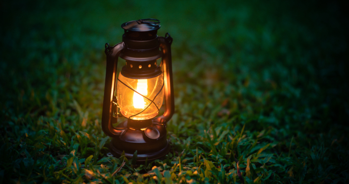 antique oil lamp On the grass in the forest in the evening camping atmosphere.Travel Outdoor Concept image